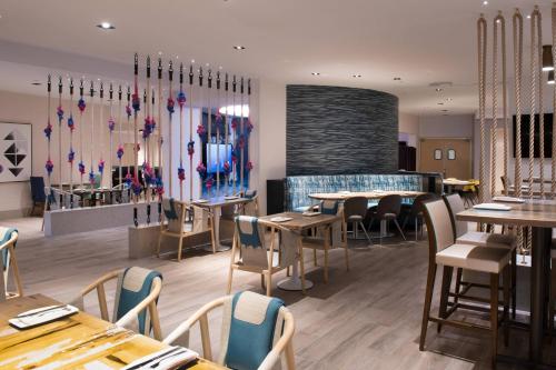 a restaurant with wooden tables and chairs and a bar at Renaissance Newport Beach Hotel in Newport Beach