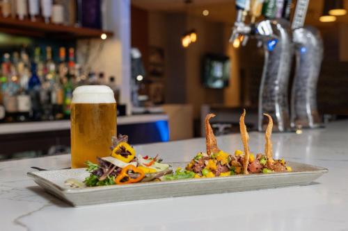 a plate of food and a glass of beer at Renaissance Newport Beach Hotel in Newport Beach