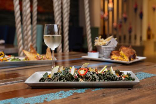 a plate of food and a glass of wine on a table at Renaissance Newport Beach Hotel in Newport Beach