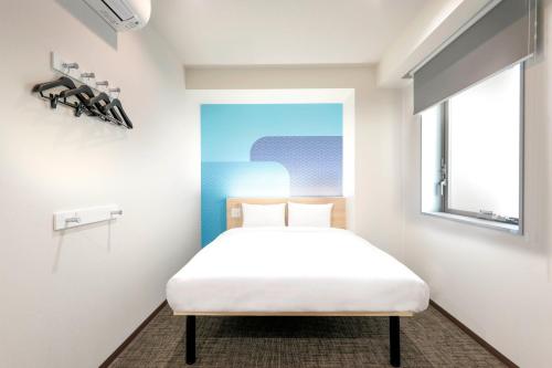 a bedroom with a white bed and a window at Hop Inn Tokyo Asakusa in Tokyo