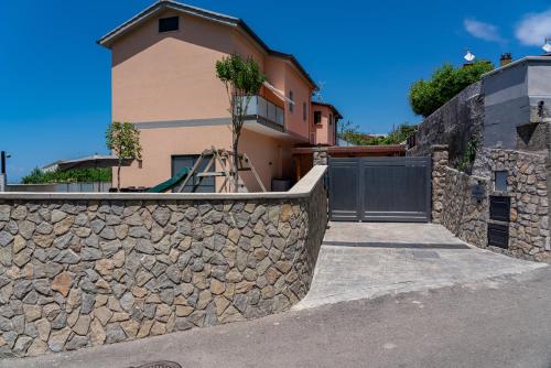 a stone retaining wall next to a house at La Stella dei venti in Vico Equense