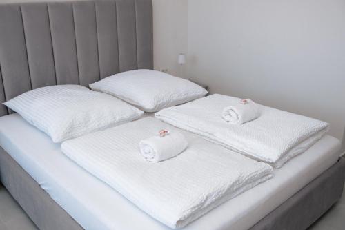 a white bed with two white towels on it at Silver Moon Residence 1 in Arad