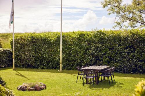 a table and chairs in the grass next to a flag at WestCord Hotel de Wadden in Oost-Vlieland