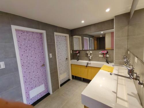a bathroom with two sinks and a purple door at Jiufen Mountain Stay in Jiufen