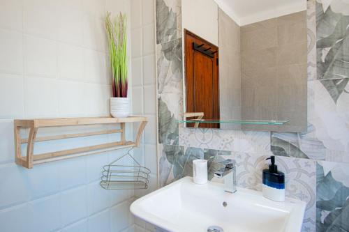 a bathroom with a sink and a mirror at UFitness Retreat Guesthouse in Vila Real de Santo António