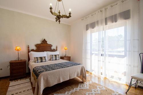 a bedroom with a bed and a large window at UFitness Retreat Guesthouse in Vila Real de Santo António