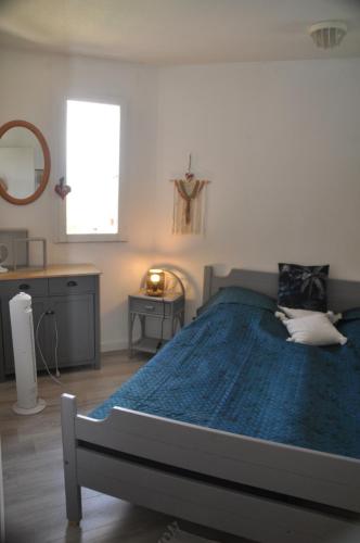une chambre avec un grand lit avec une couette bleue dans l'établissement Ker Armelle, au Barcarès