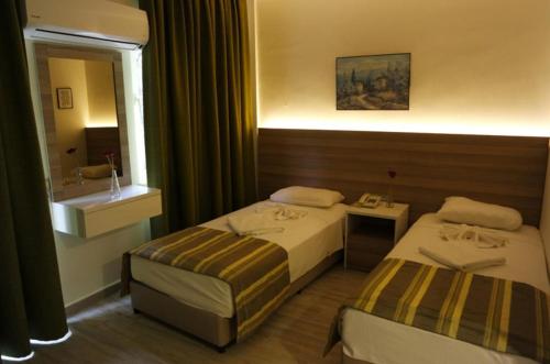a hotel room with two beds and a mirror at Amphi Apart in Marmaris