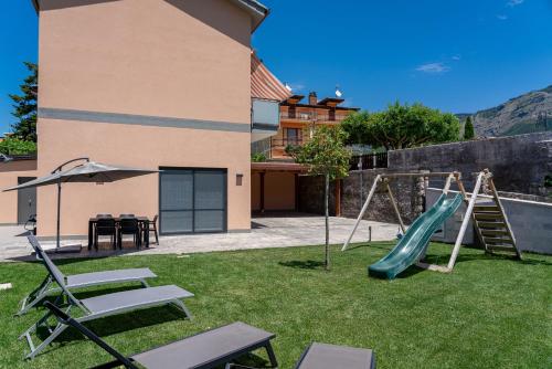 a yard with a playground with a slide and chairs at La Stella dei venti in Vico Equense