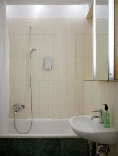 a bathroom with a shower and a sink and a tub at Wedina Budget in Hamburg