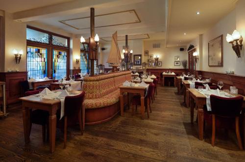 a restaurant with tables and a couch and chairs at WestCord Hotel de Wadden in Oost-Vlieland