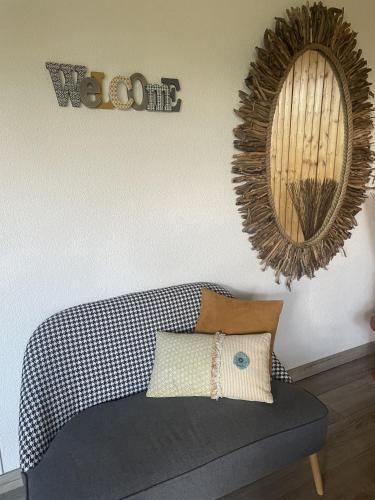 un salon avec un canapé et un miroir dans l'établissement Le Domaine de la Caille - L'Hôtel, à La Balme-de-Sillingy