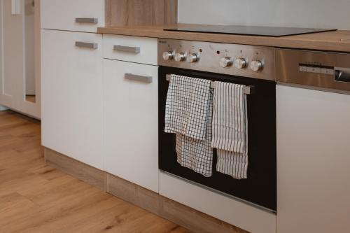 a kitchen with a stove with towels on the oven at Kalkalpen Apartments in Spital am Pyhrn