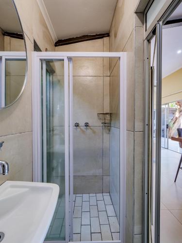 a glass shower in a bathroom with a sink at Private Studio flatlet, Uncapped Wifi, Netflix,Full DSTV in Durban