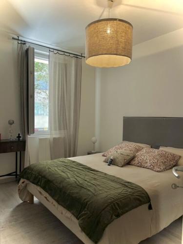 une chambre avec un lit et une grande fenêtre dans l'établissement Joli T2 central face a la plage, à Ajaccio