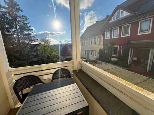 a porch with a bench and a window with the sun at Ferienwohnung Daisy in Sankt Andreasberg