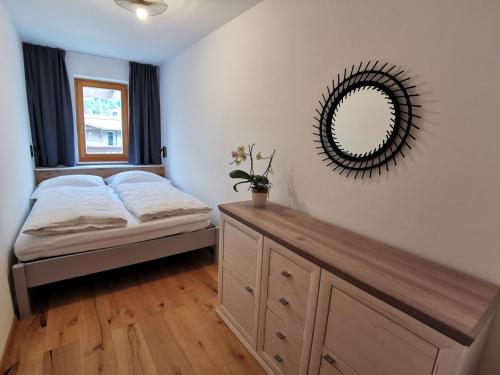 a bedroom with a bed and a mirror on the wall at Schlossalm Appartement in Bad Hofgastein