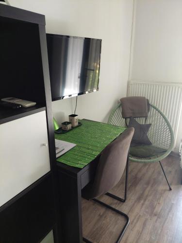 a desk with a green table and a chair at Szalay Villa in Veszprém