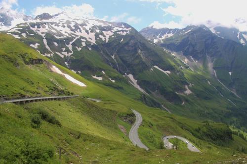 a winding road on a mountain with snow covered mountains at Thurners Dependance in Bruck an der Großglocknerstraße