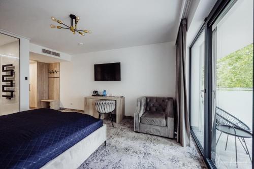a bedroom with a bed and a chair and a window at Cristal in Ustka