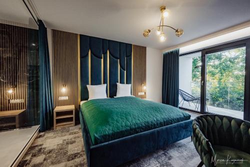 a bedroom with a green bed and a large window at Cristal in Ustka