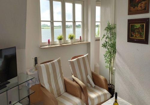un salon avec deux chaises et une télévision dans l'établissement Haus am Schlei Noor, à Maasholm