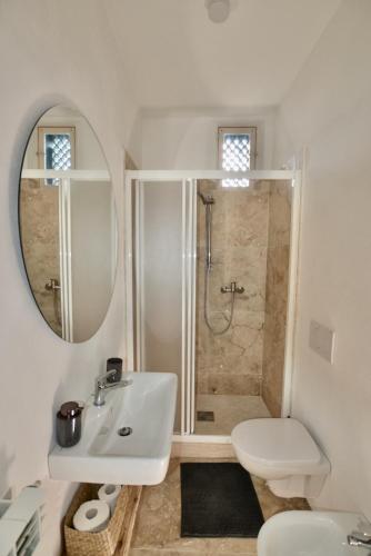 a white bathroom with a sink and a shower at Casa blu in Rapolano Terme