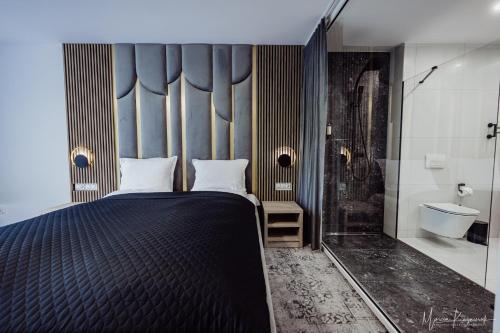 a bedroom with a bed and a bathroom with a shower at Cristal in Ustka