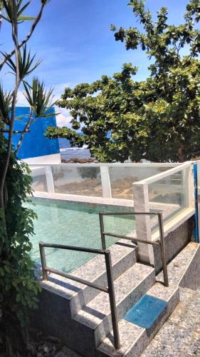 a chair sitting on the stairs next to the water at Glass Palace House Rental in San Vicente