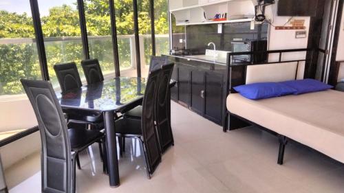a dining room with a table and chairs and a kitchen at Glass Palace House Rental in San Vicente