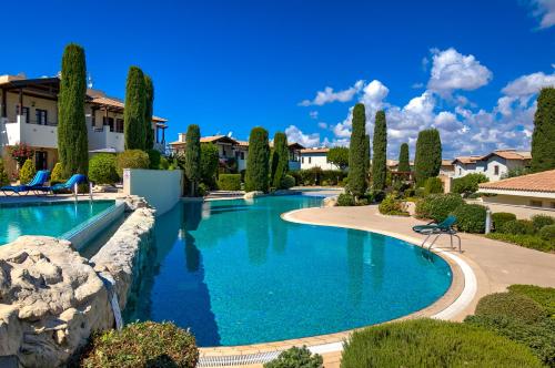 a swimming pool in a villa with trees at 2 bedroom Apartment Chloe with communal pool, Aphrodite Hills Resort in Kouklia
