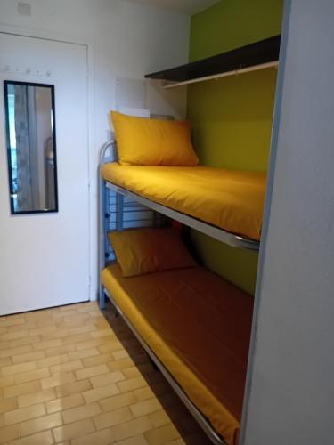 カップ・ダグドにあるAppartement avec parking privé dans résidence les hautes vignesの二段ベッド2台とドアが備わる客室です。