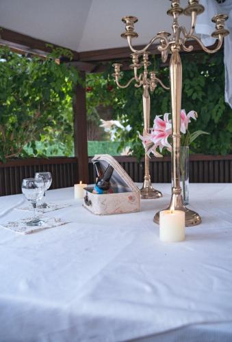 a table with a white table cloth and a basket of flowers at Vikendica Drinski mir in Loznica