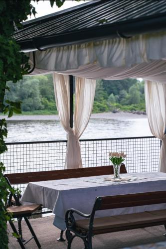 a table with a vase on it with a view of a river at Vikendica Drinski mir in Loznica
