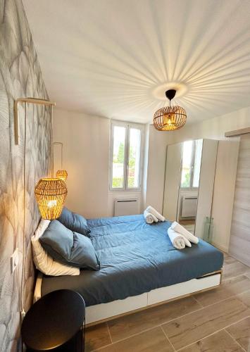 - une chambre avec un lit bleu et un lustre dans l'établissement Charmant appartement calme et élégant à 5 min des plages, à Toulon