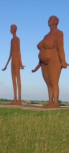 a statue of two people standing in a field at stacaravan Mientje in Hantum
