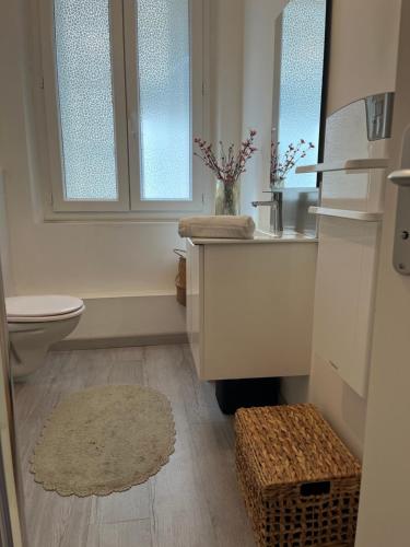 une salle de bain avec un lavabo et des toilettes et des fenêtres dans l'établissement Joli T2 central face a la plage, à Ajaccio