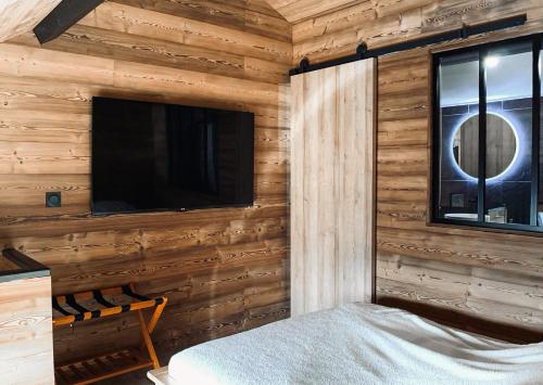 a room with a wall with a tv and a bed at Le refuge secret appartement cosy avec garage in Les Angles