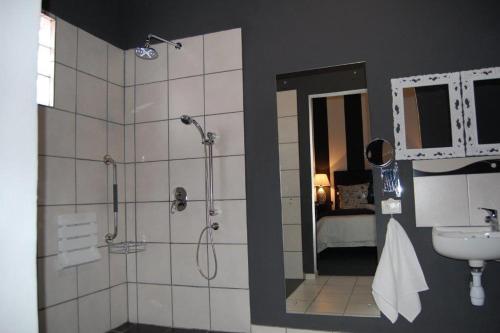 un bagno con doccia e lavandino di 7 Cities Guesthouse a Cradock