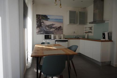 une petite cuisine avec une table et des chaises en bois dans l'établissement Appartement Suite Privilège avec Parking, à Salon-de-Provence