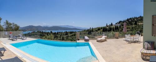 a large swimming pool with a view of a lake at Koumaries Villas in Lygia
