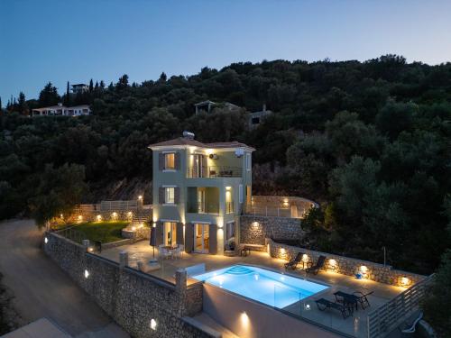 a large house with a swimming pool in front of it at Koumaries Villas in Lygia
