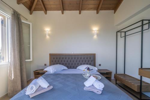 a bedroom with a blue bed with towels on it at Koumaries Villas in Lygia