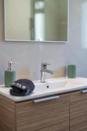 a bathroom sink with a mirror and a towel at Koumaries Villas in Lygia