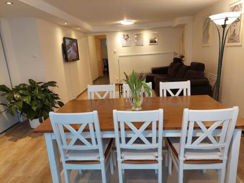 a dining room with a table and white chairs at Lägenhet på landet nära stan in Jonsered