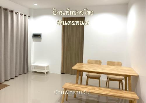 a wooden table and two chairs in a room at บ้านพักชายโขง นครพนม b2 in Nakhon Phanom