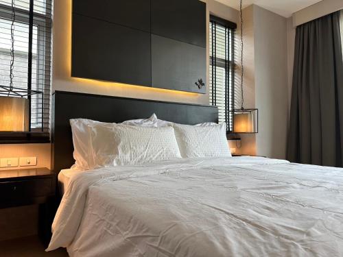 a large white bed in a bedroom with two lamps at Metthods living11 in Ban Fon