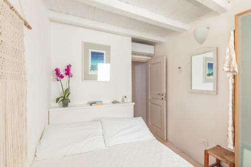 a bedroom with white walls and a bed with flowers on it at Elena's house 28 in Polignano a Mare