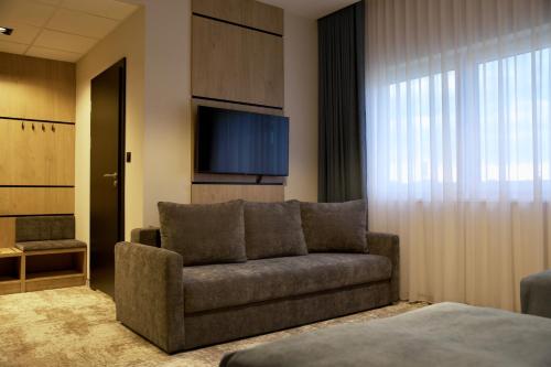 a living room with a couch and a flat screen tv at Sarmata in Czyżówek