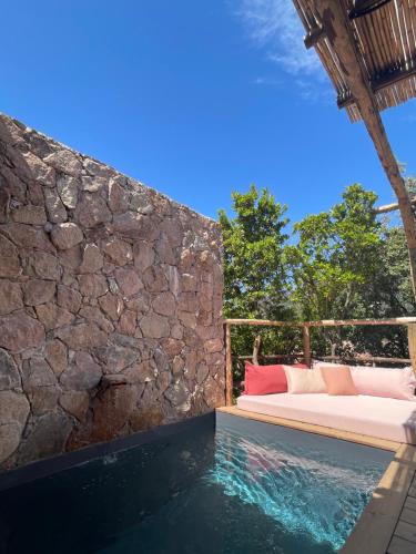 une chambre avec un lit et un mur en pierre dans l'établissement Les Petites Maisons, à Sotta